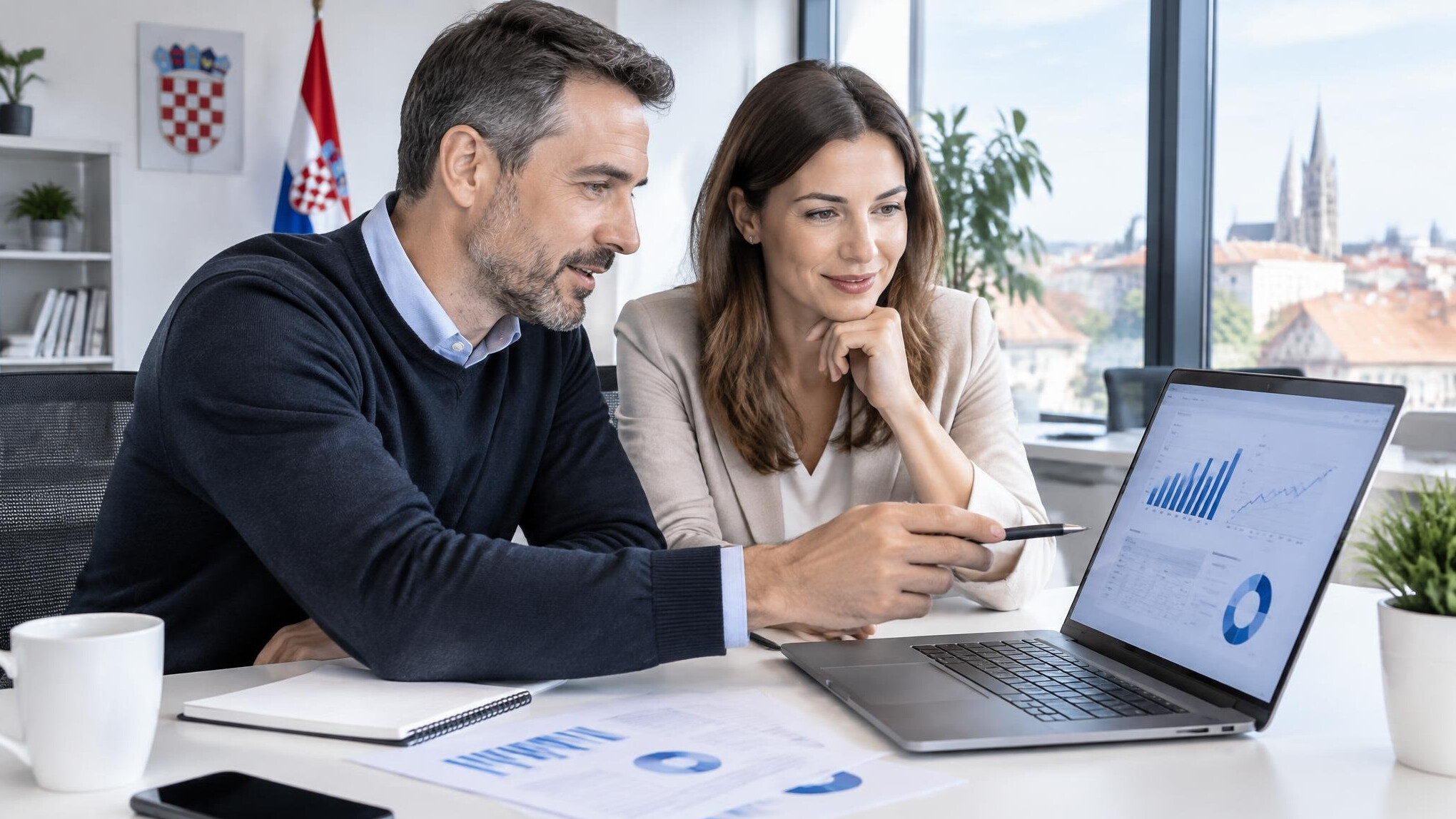 Team reviewing data charts on a laptop in a modern office